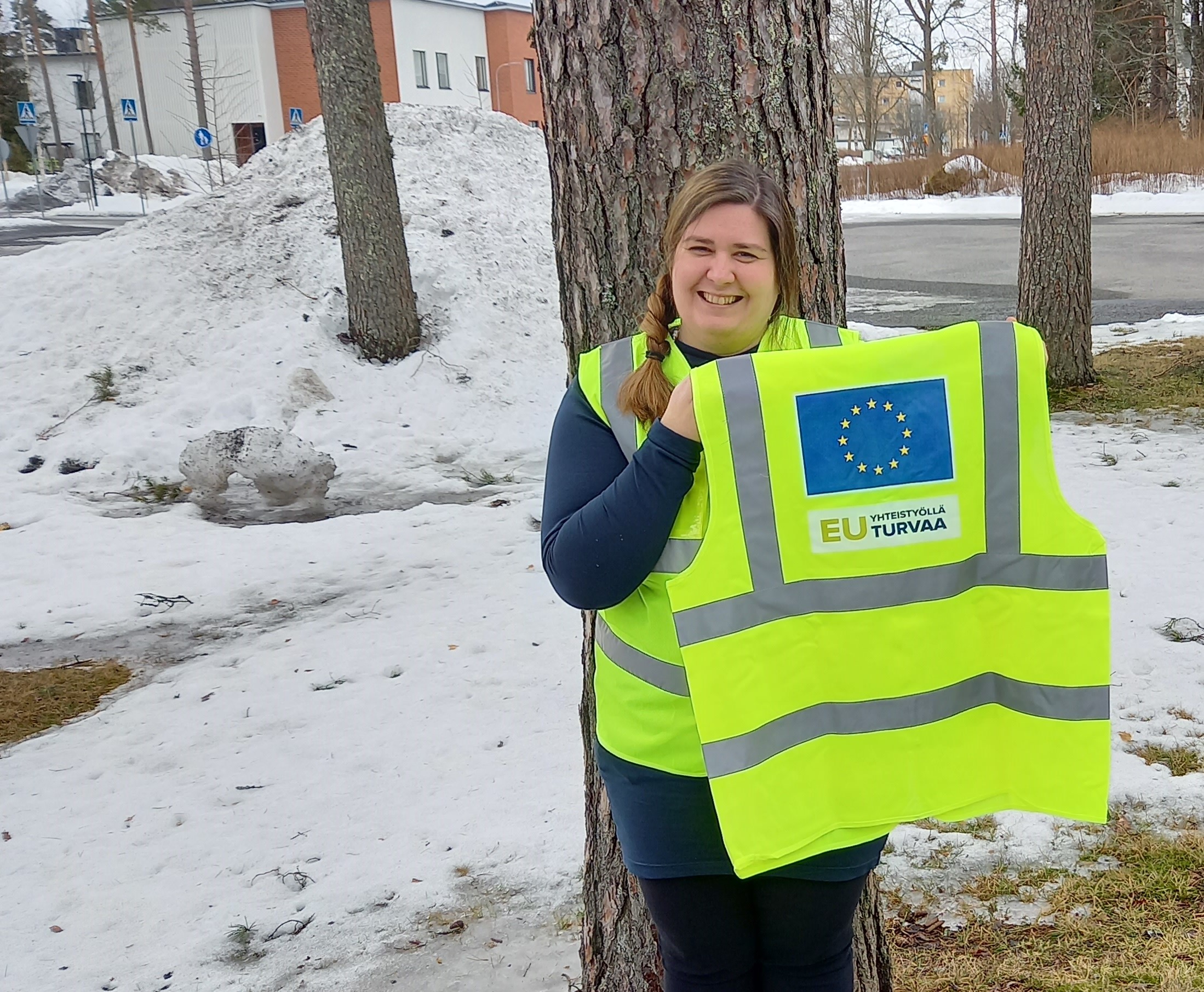 Nainen esittelee turvaliiviä, jossa EU lipuu ja teksti EU turvaa