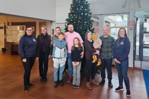 Merikarvian asumiskokeilijat sekä hankkeen työntekijät yhteiskuvassa Merikarvian kunnantalolla joulukuusen edessä.