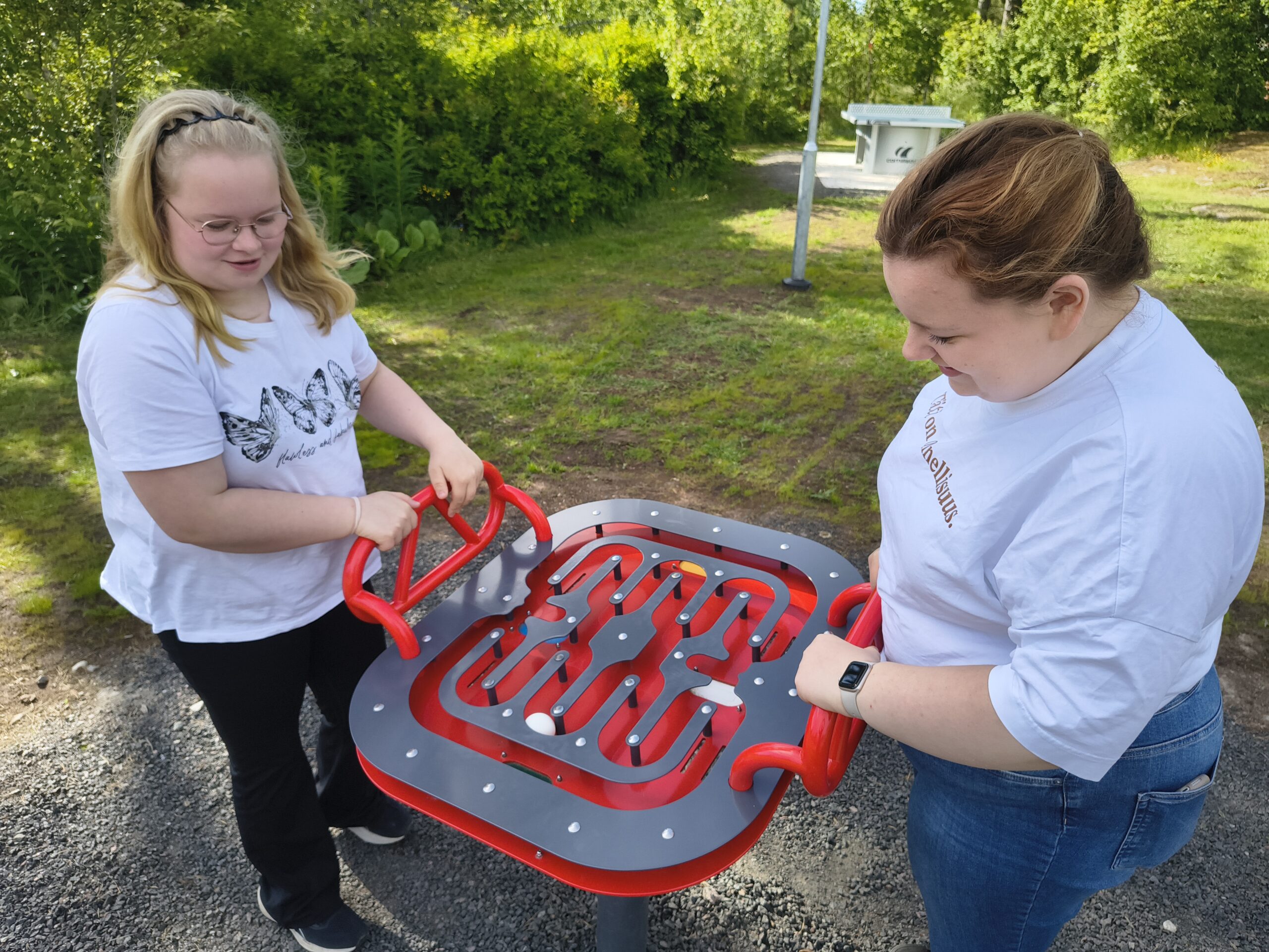 Kaksi nuorta pelaa ulkoliikuntapaikan pelejä.