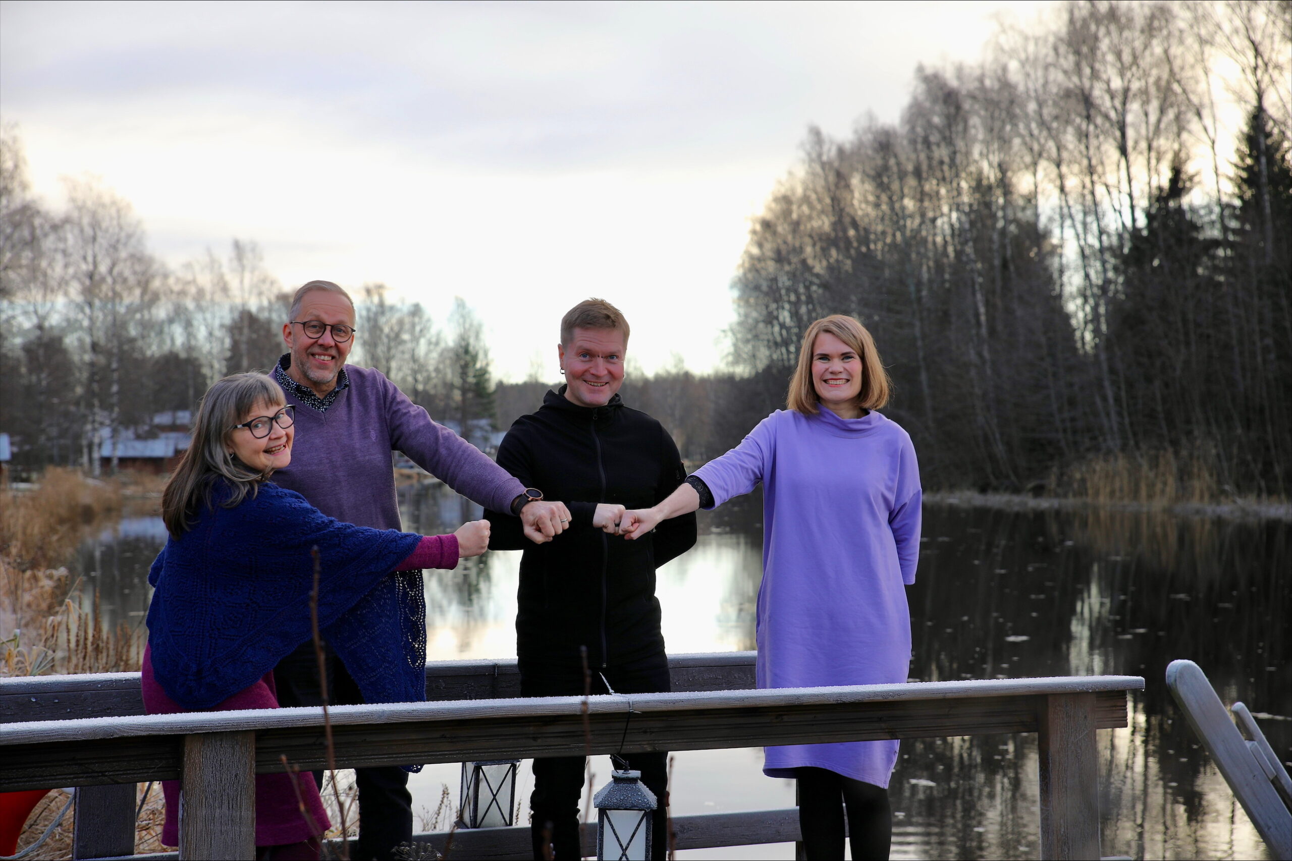 Neljä henkilöä joen rannalla.