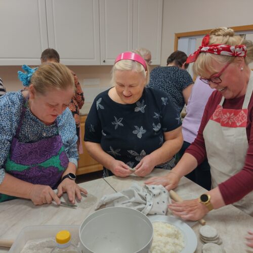 Naiset leipovat karjalanpiirakoita.