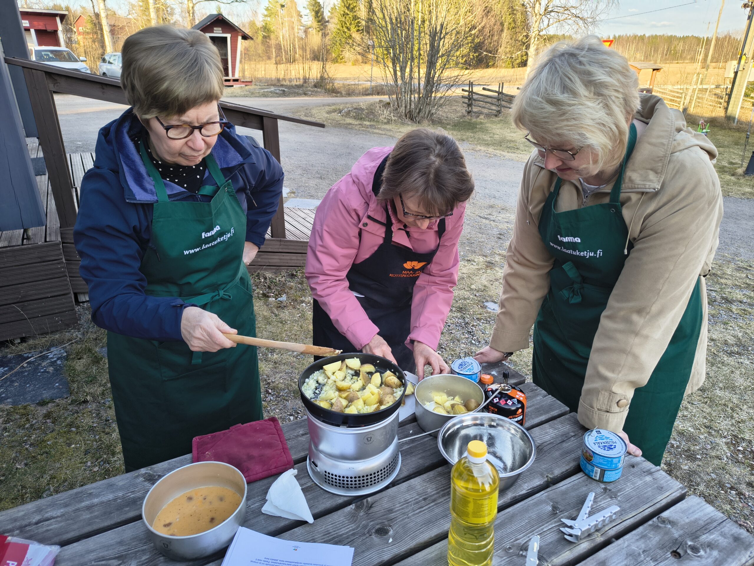 Naiset kokkaavat trangialla.