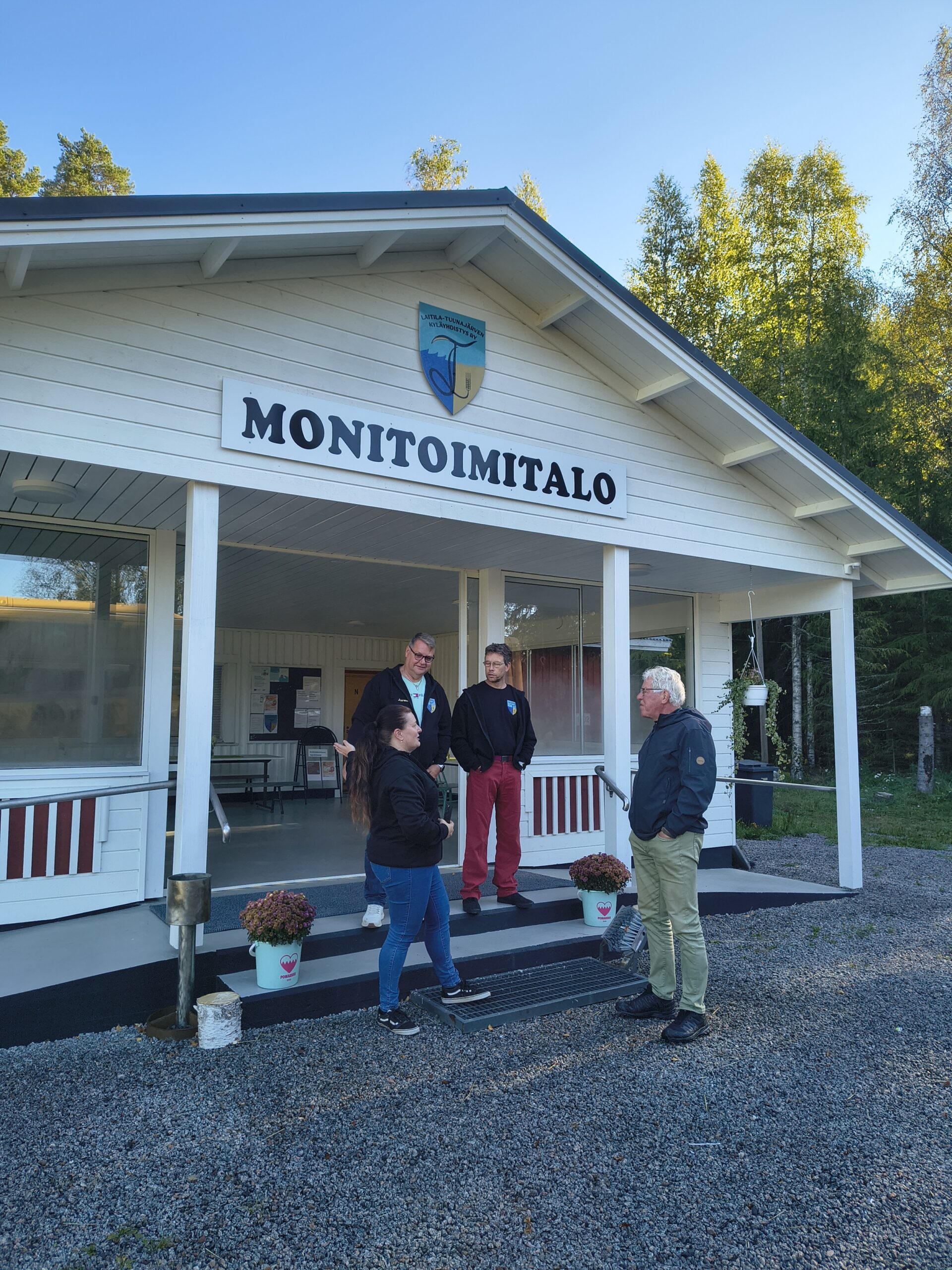 Ihmisiä kylätalon portailla.
